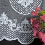 Stilvoll weiß bestickte Gardine mit ornamentalem Muster am Boden