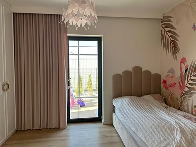 Ein M&auml;dchenzimmer in hellen Farben mit rosa Vorh&auml;ngen